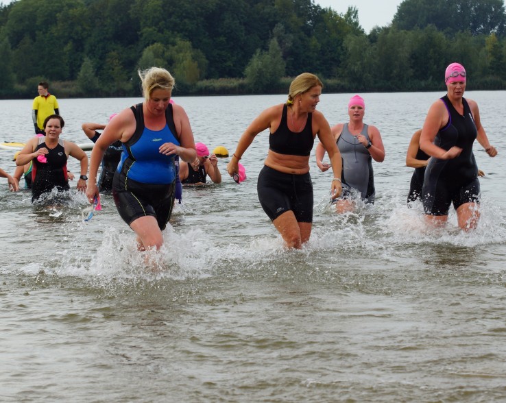 Deelneemsters komen na het zwemmen het water uit