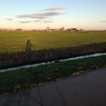 Foto zonnig Fries landschap met schaduw fietser