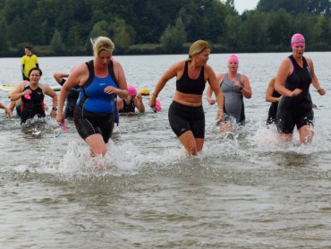 Deelneemsters komen na het zwemmen het water uit
