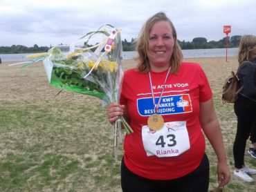 Rianka in KWF-shirt na de finish met bloemen